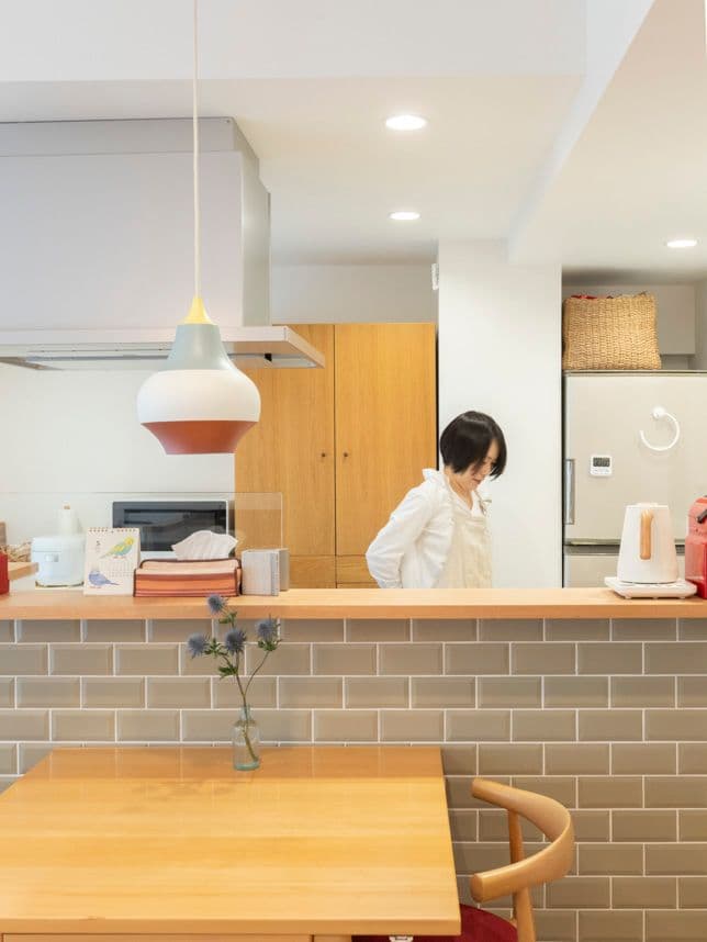 中古マンションのリノベーション後のキッチンに立つ女性