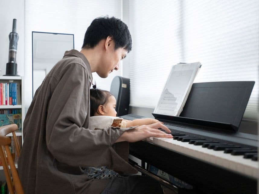 中古マンションのリノベーション後の個室のピアノを弾く親子